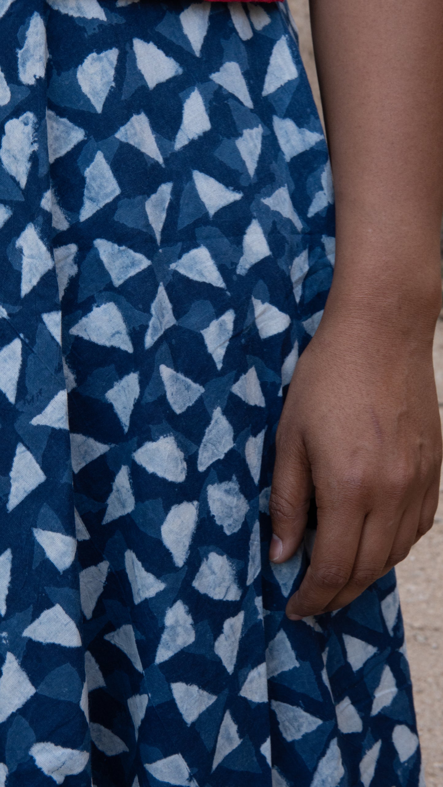 Close-up of a blue patterned fabric with a hand holding it.