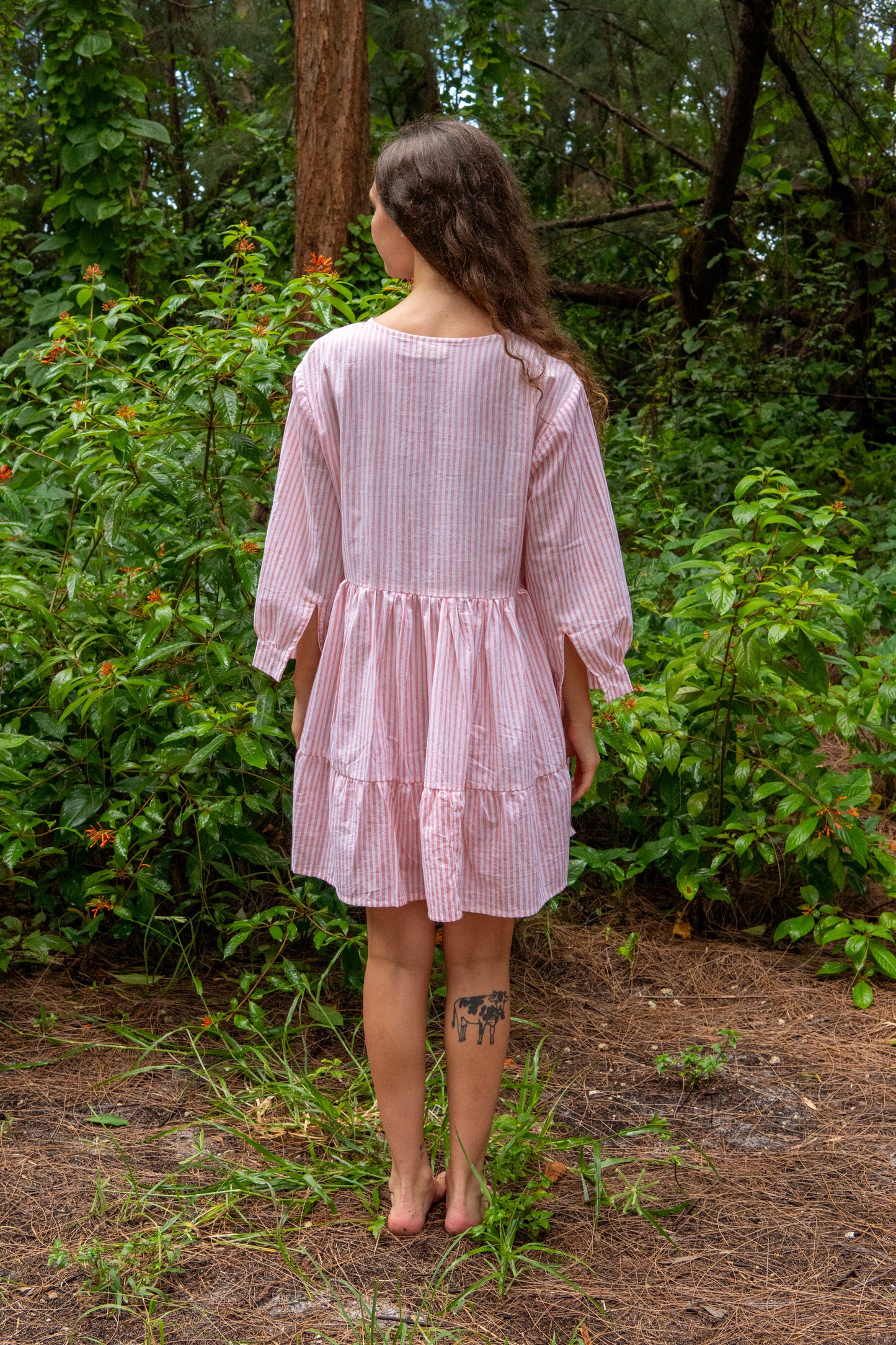 Woman in a pink dress standing in a forest