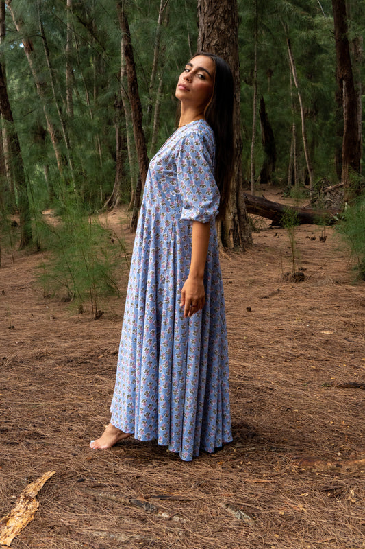 Woman in a blue dress standing in a forest