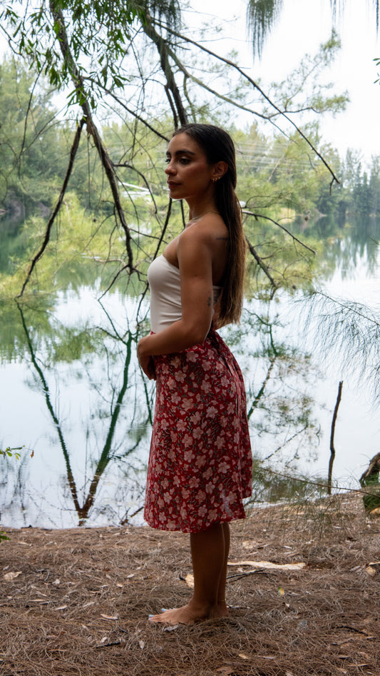 Woman standing by a lake with trees in the background