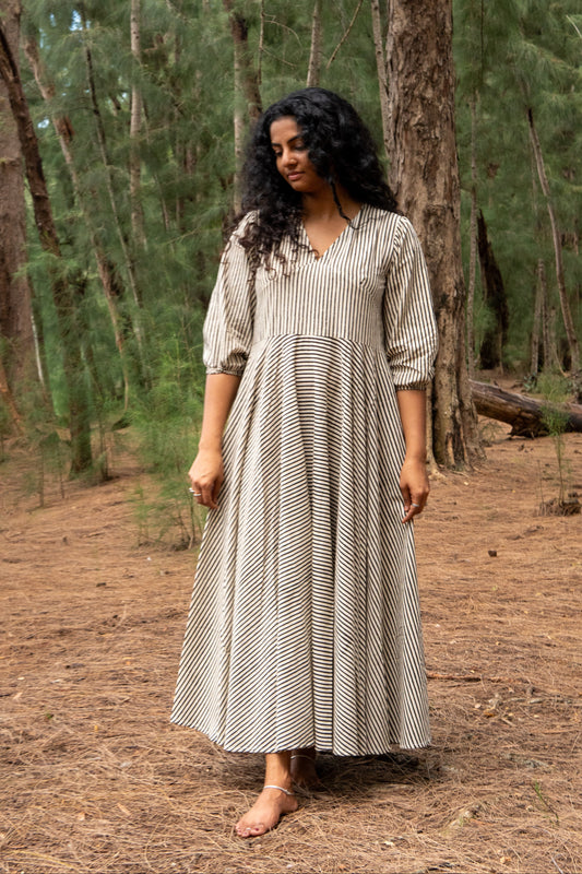 Woman in a long, patterned dress standing in a forest