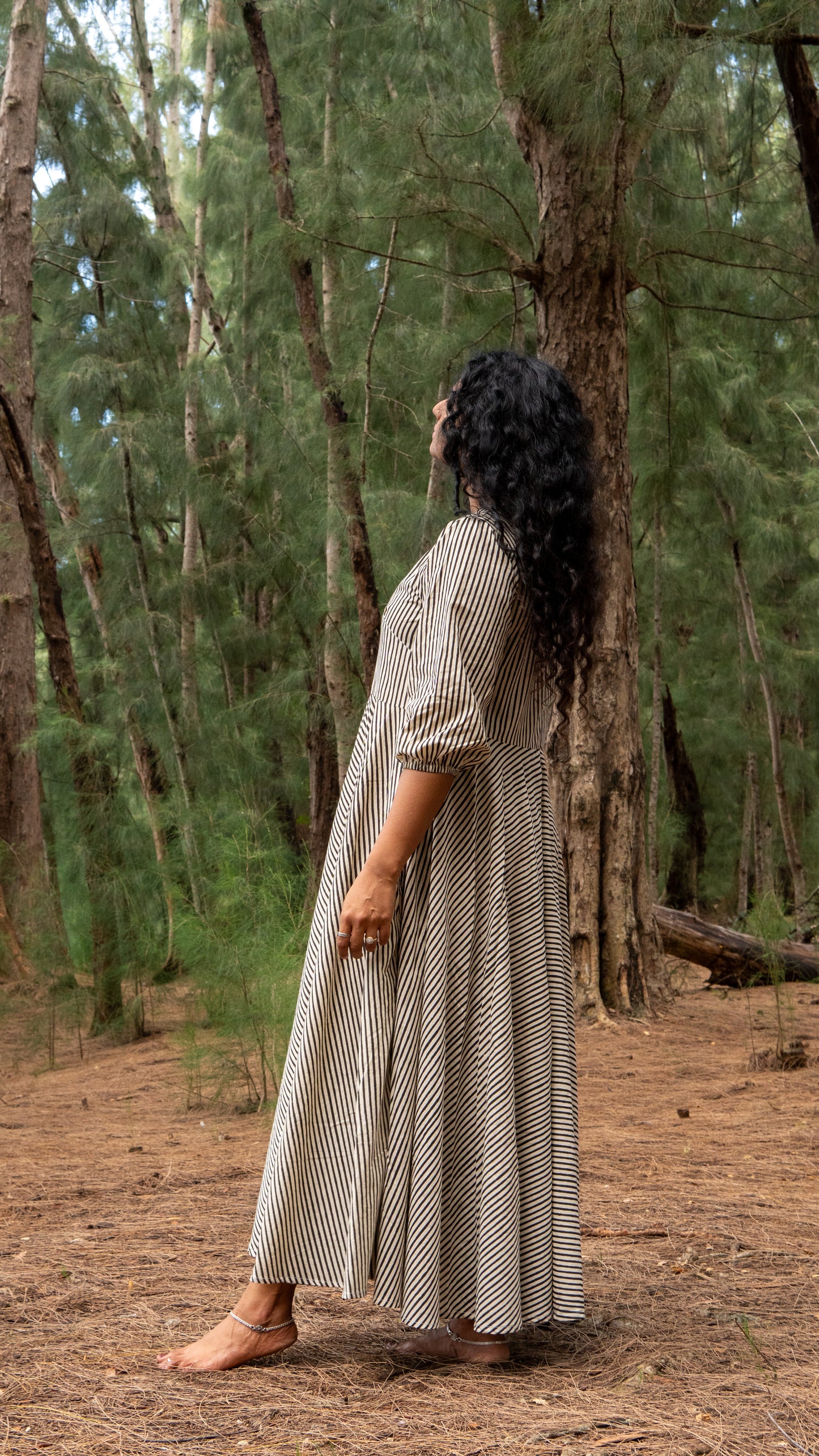 Woman in a long dress standing in a forest