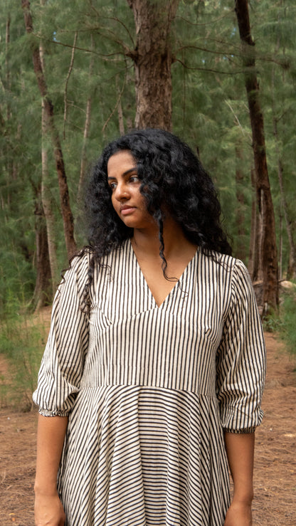 Woman in a striped dress standing in a forest