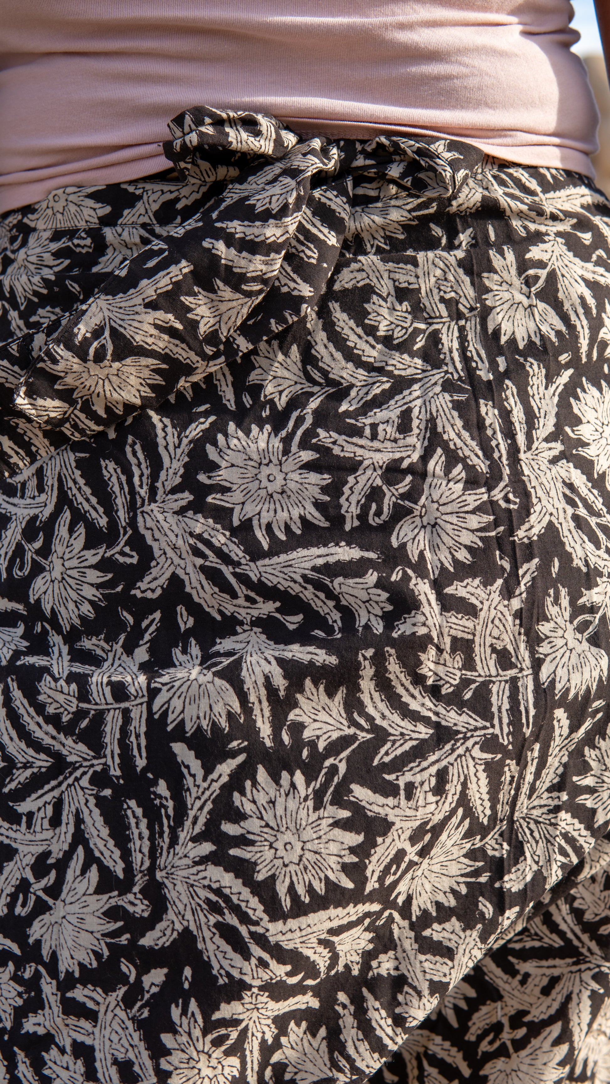 Close-up of a black fabric with white floral pattern, possibly a skirt or garment.