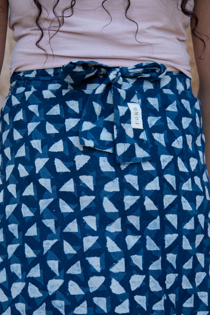 Person wearing a blue patterned skirt with a white label.