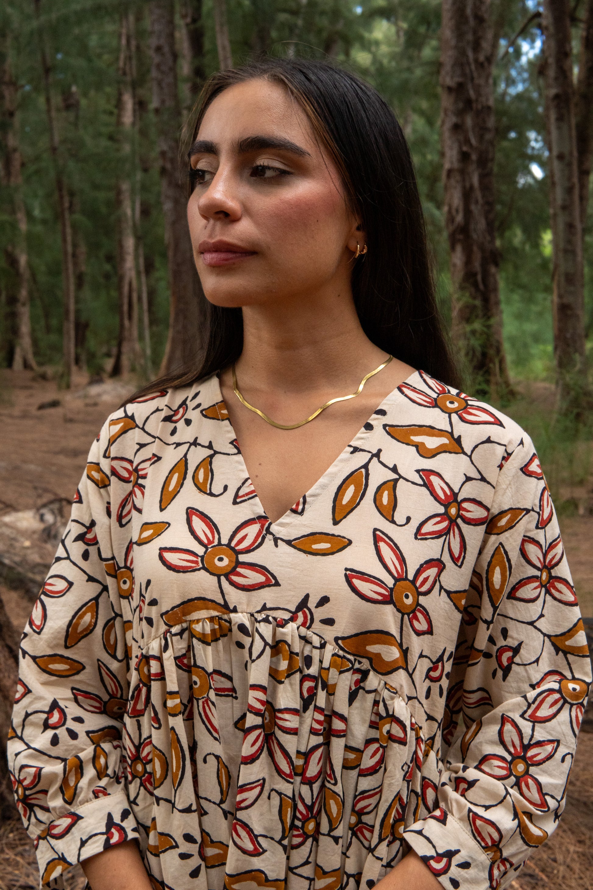 Woman wearing a floral dress in a forest setting