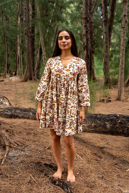 Woman in a patterned dress standing in a forest