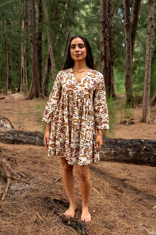 Woman in a patterned dress standing in a forest