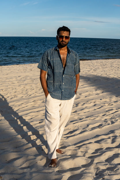 Man standing on a sandy beach with ocean in the background