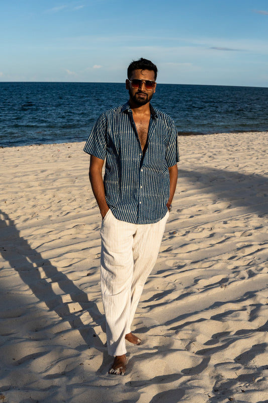 Man standing on a sandy beach with ocean in the background