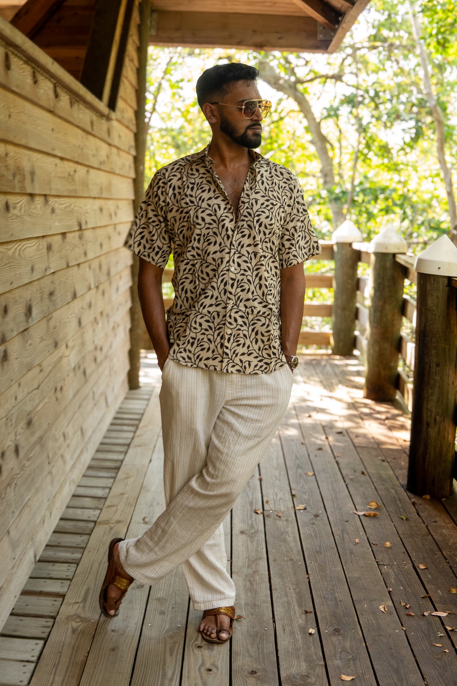 Man standing on a boardwalk wearing a botanical shirt