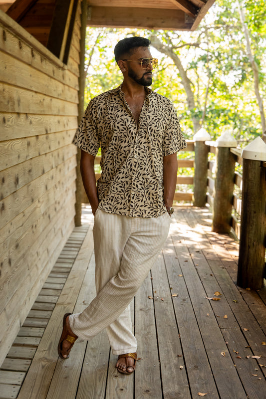 Man standing on a boardwalk wearing a botanical shirt
