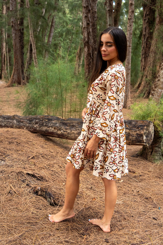 Woman in a patterned dress standing in a forest setting