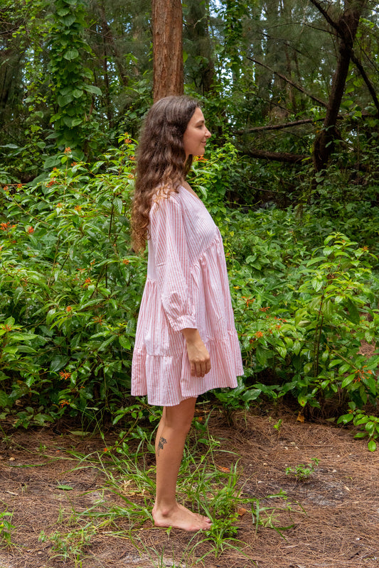 Woman in a pink dress standing in a forest setting