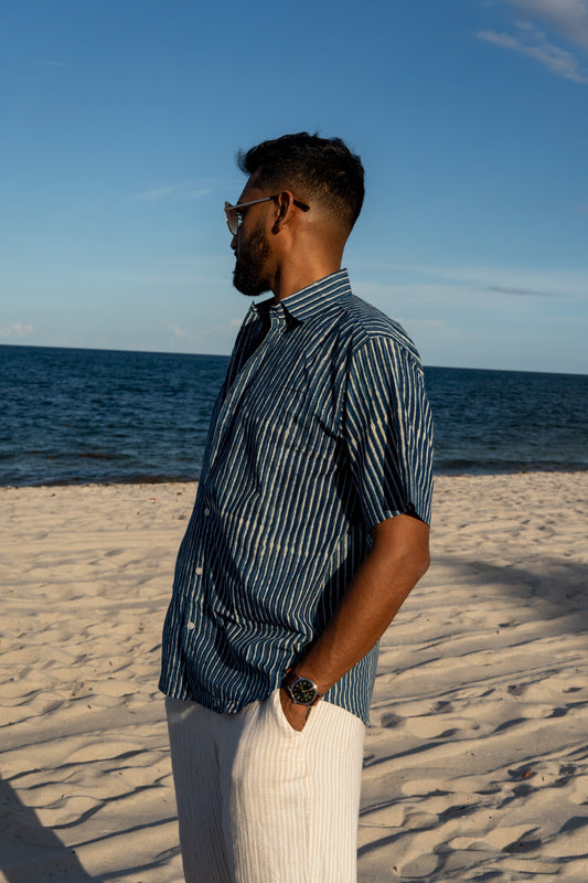 Man standing on a sandy beach with ocean view