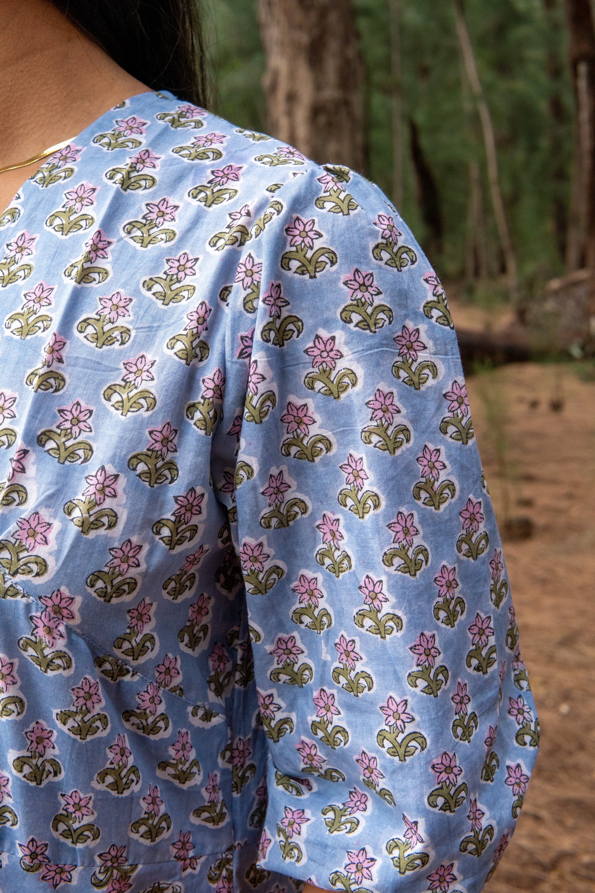 Blue floral-patterned fabric draped over a person with a natural background